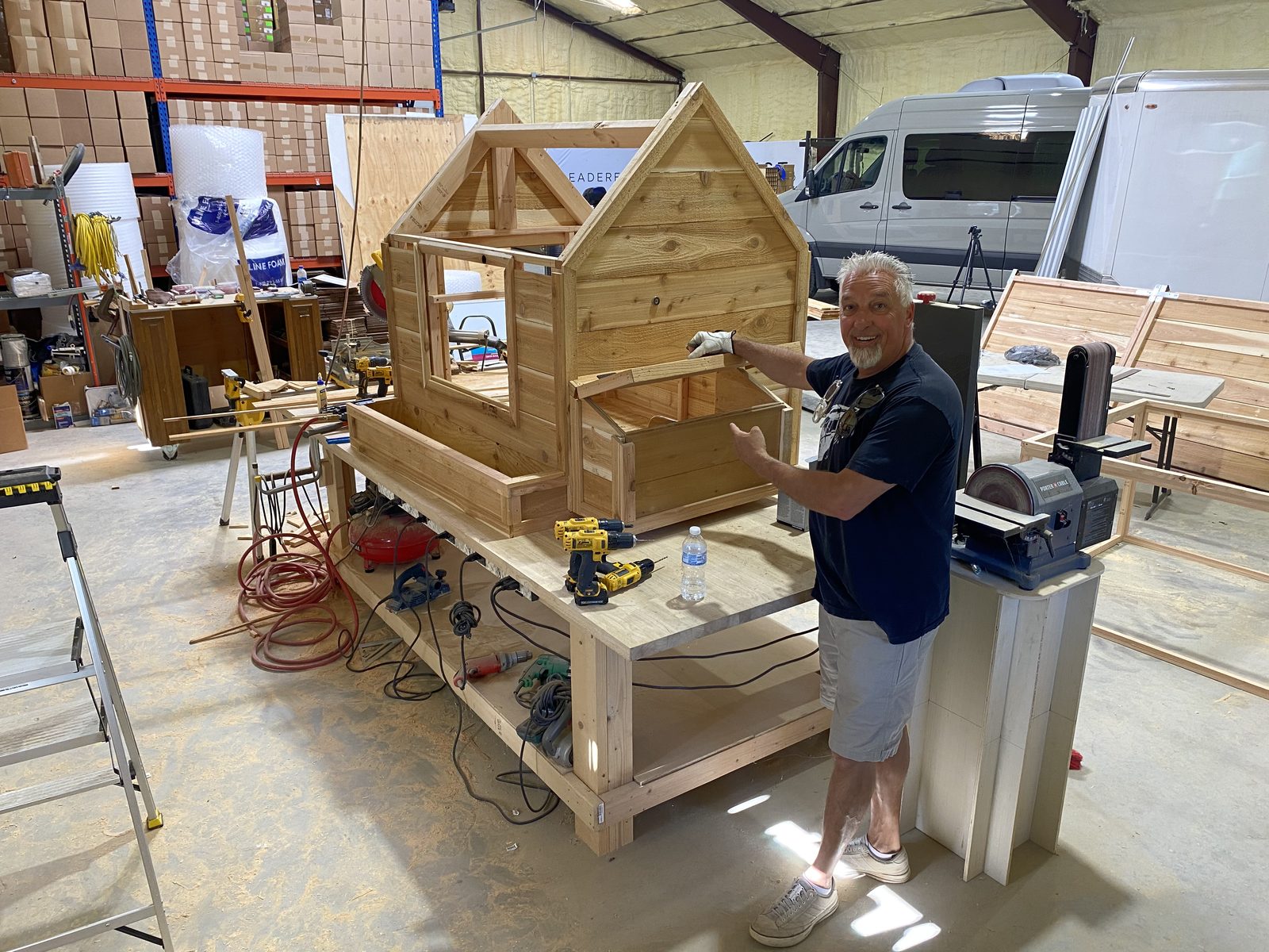 Rick Hopper in his workshop showing a custom cedar playhouse build
