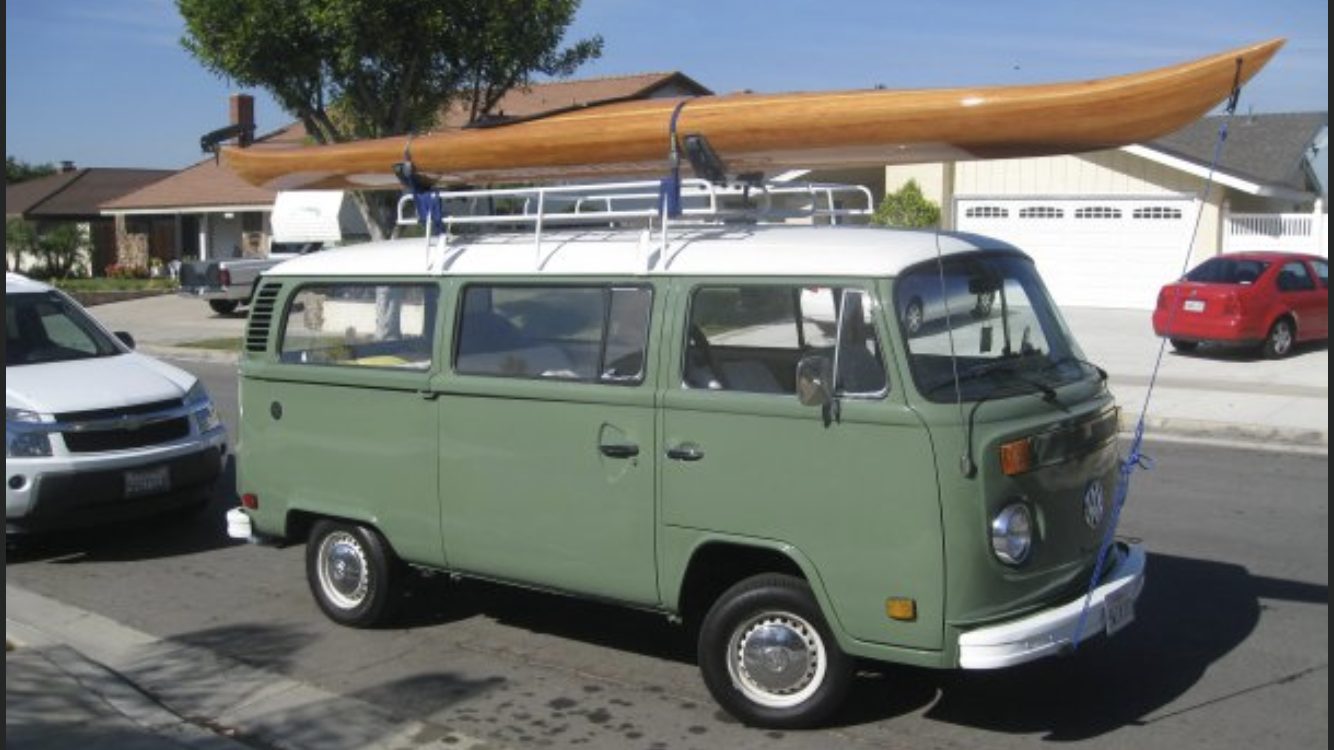 Rick Hopper's vintage VW bus with a handmade wooden kayak on the roof rack