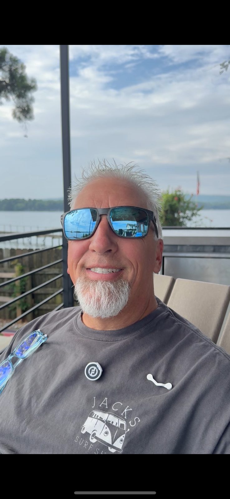 Rick Hopper relaxing lakeside wearing sunglasses and a Readerest magnetic holder