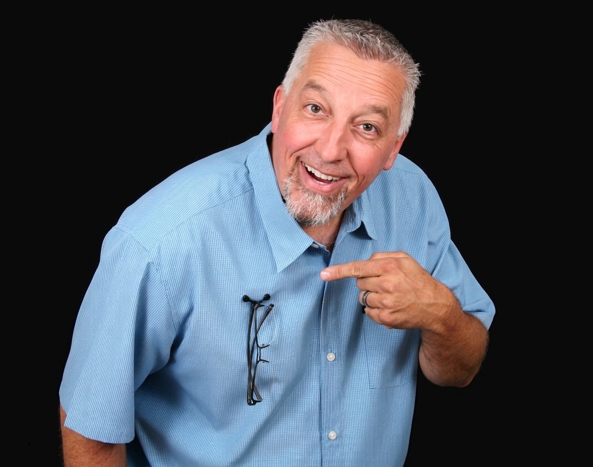 Rick Hopper, inventor of Readerest and Shark Tank Season 3 alumni, pointing at the magnetic eyeglass holder on his shirt